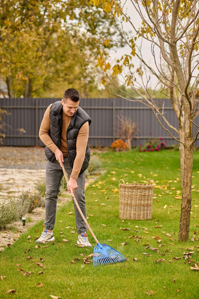 A man raking his yard to remove debris