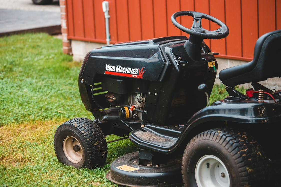 Professional landscaper using commercial mower on a healthy green residential lawn