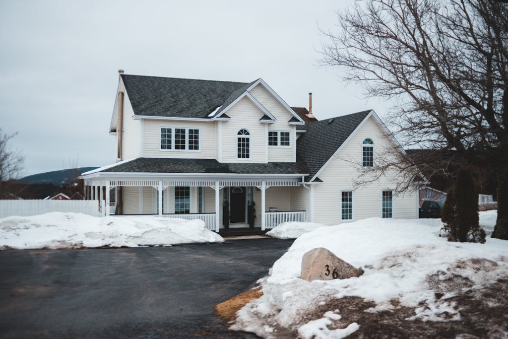 Snow-covered residential property with a cleared driveway and walkway, demonstrating winter surface care techniques designed to enhance safety during freezing conditions